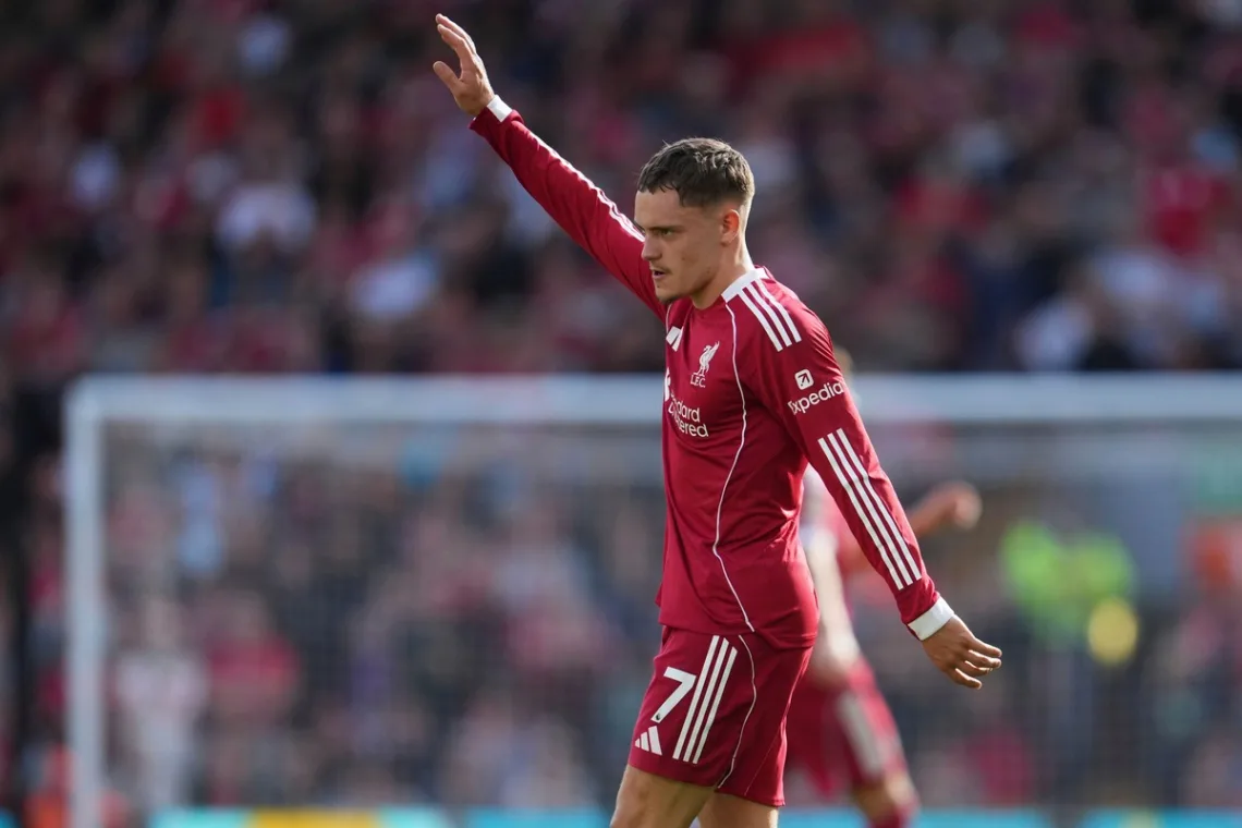 Grafika przedstawiająca piłkarza z ręką uniesioną ku górze.