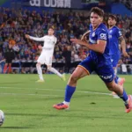 Grafika przedstawiająca piłkarza biegnącego za piłką.