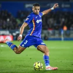 Grafika przedstawiająca piłkarza uderzającego piłkę.