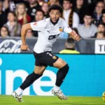 Grafika przedstawiająca piłkarza biegnącego z piłką przy nodze.