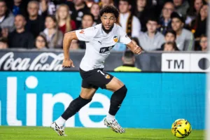 Grafika przedstawiająca piłkarza biegnącego z piłką przy nodze.