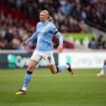 Grafika przedstawiająca biegnącego piłkarza