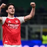 Grafika przedstawiająca piłkarza z rękami w górze.