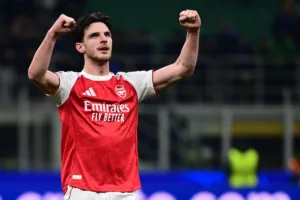 Grafika przedstawiająca piłkarza z rękami w górze.