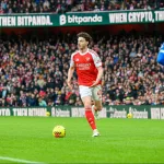 Grafika przedstawiająca piłkarza z piłką przy nodze.